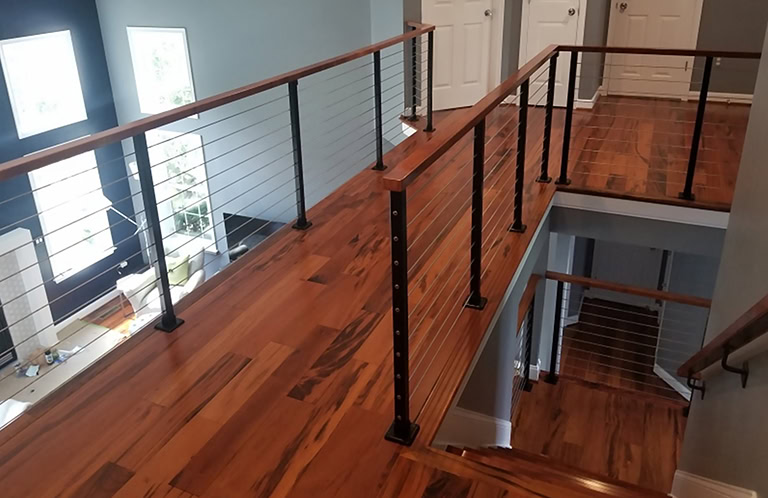 black steel cable railing with wood handrail cap